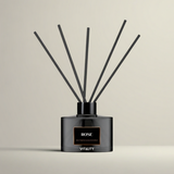 Rose reed diffuser bottle with black reeds in glass container